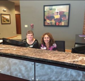 Two women smiling at the front desk